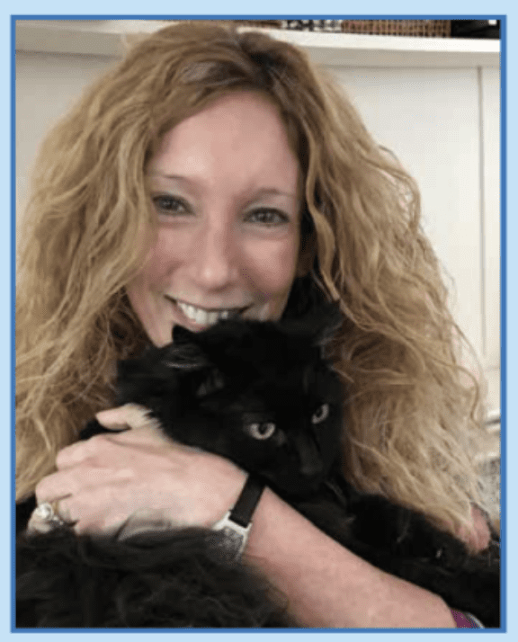 A woman holding a black cat.