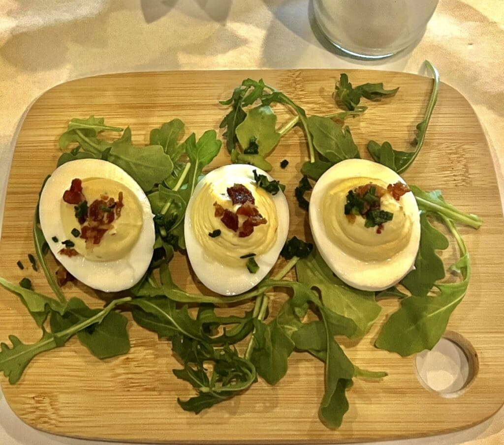 Deviled eggs with bacon and arugula.