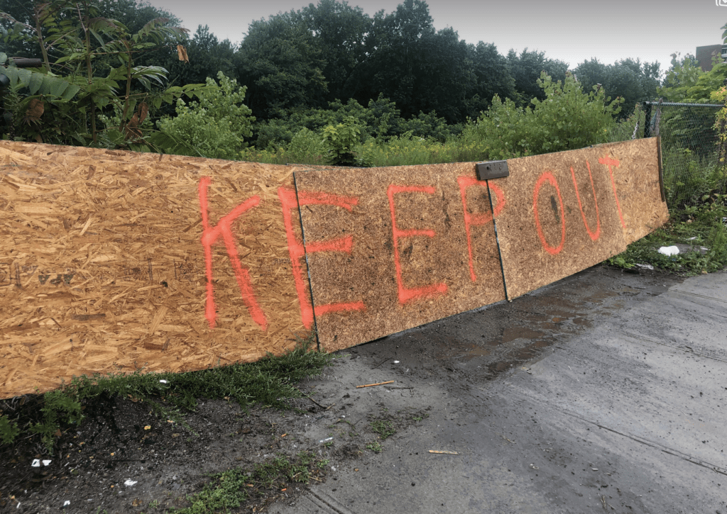 A piece of plywood with the words keep out written on it.