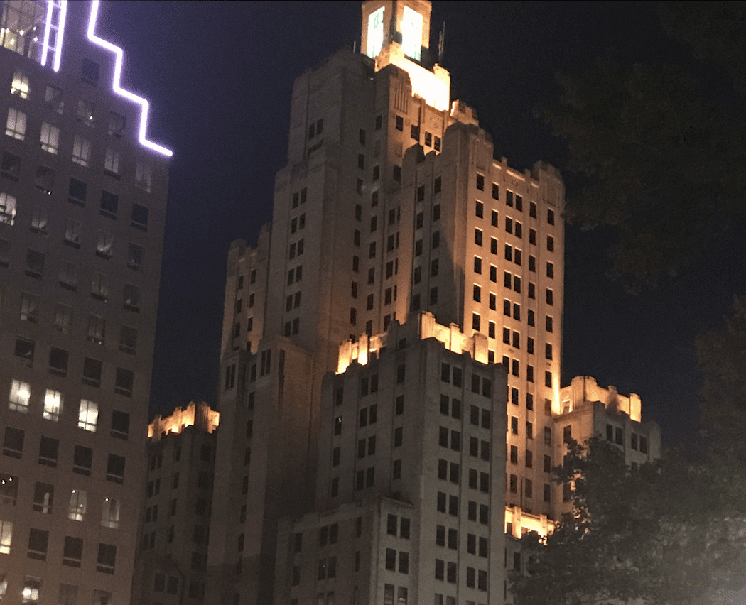 A tall building in Providence lit up at night.