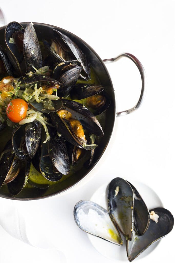 Recipe: Mussels in a pot on a white plate.