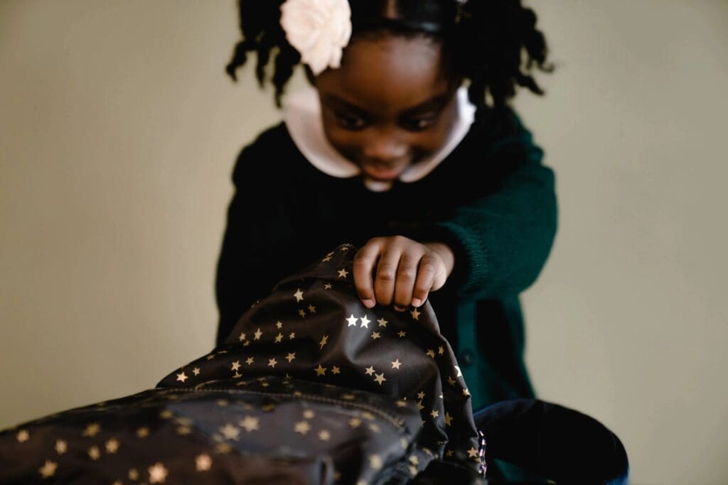 A little girl opening up a bag with stars on it.