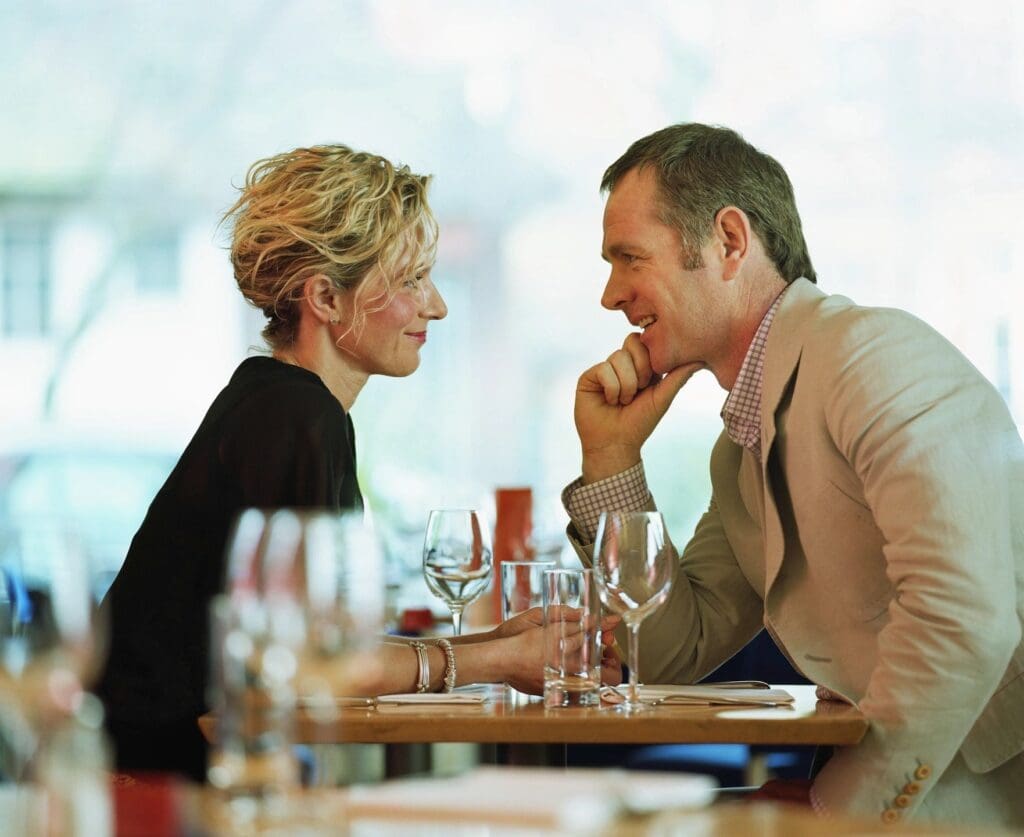 A man and woman sitting at a table in a restaurant.