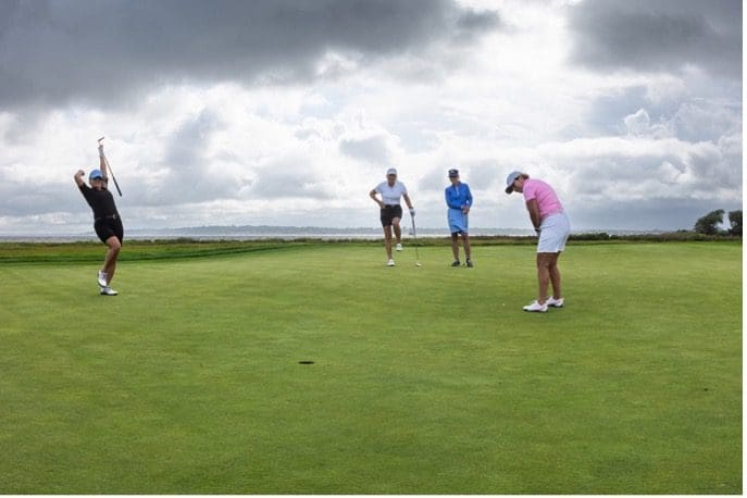 A group of hospice patients playing golf under a cloudy sky.
