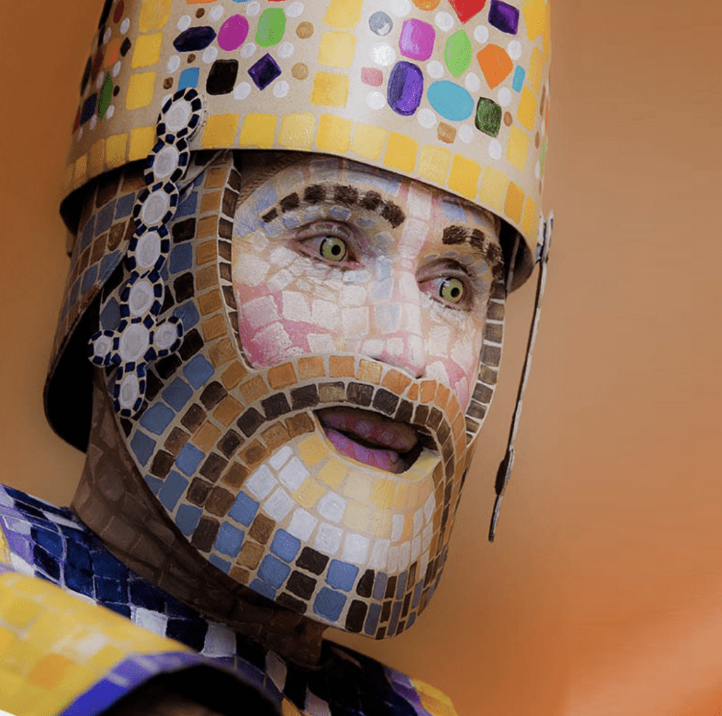 A man with a beard is wearing an art-inspired mosaic hat.