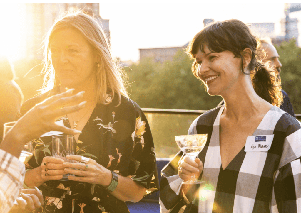 A group of women networking at an event in London, enjoying a glass of wine.