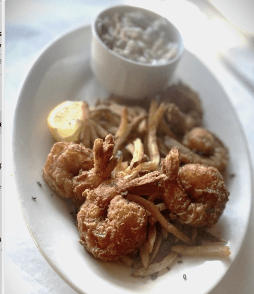 Delicious fried shrimp recipe served on a white plate with a tantalizing dipping sauce.