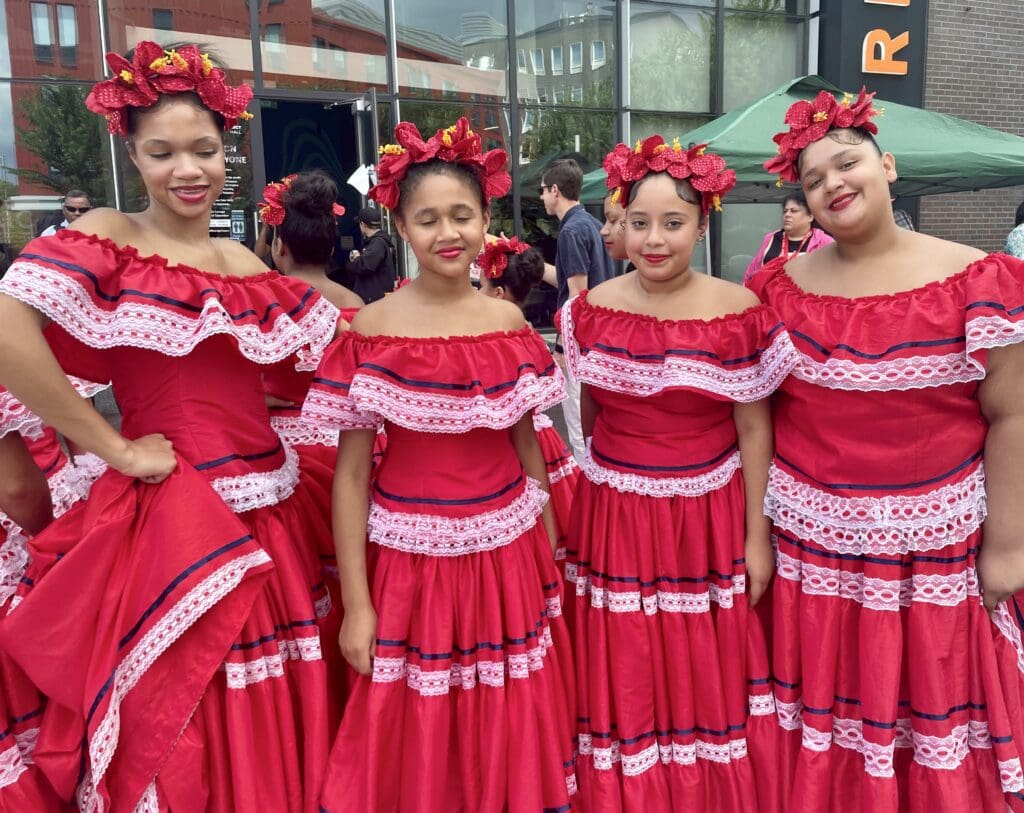 A group of mexican girls in red dresses posing for a photo.