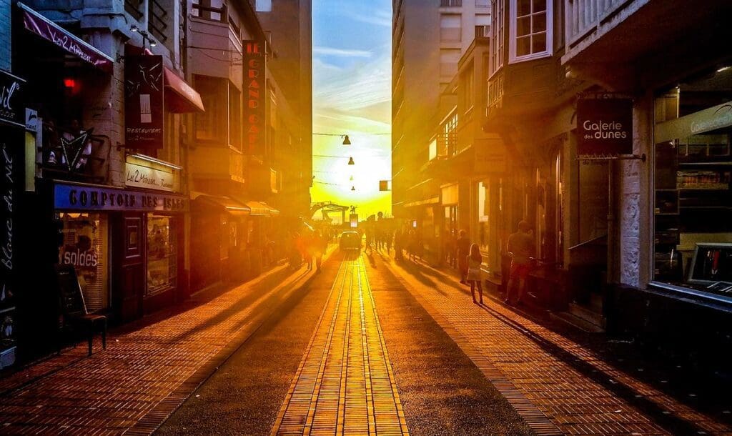 The sun is setting over a city street.