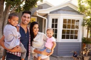 A family standing in front of their new home.