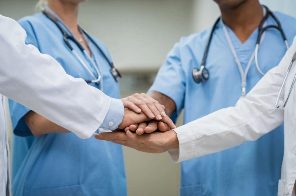 A group of doctors shake hands in a hospital.