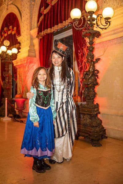 A woman and a little girl dressed up in Halloween costumes.