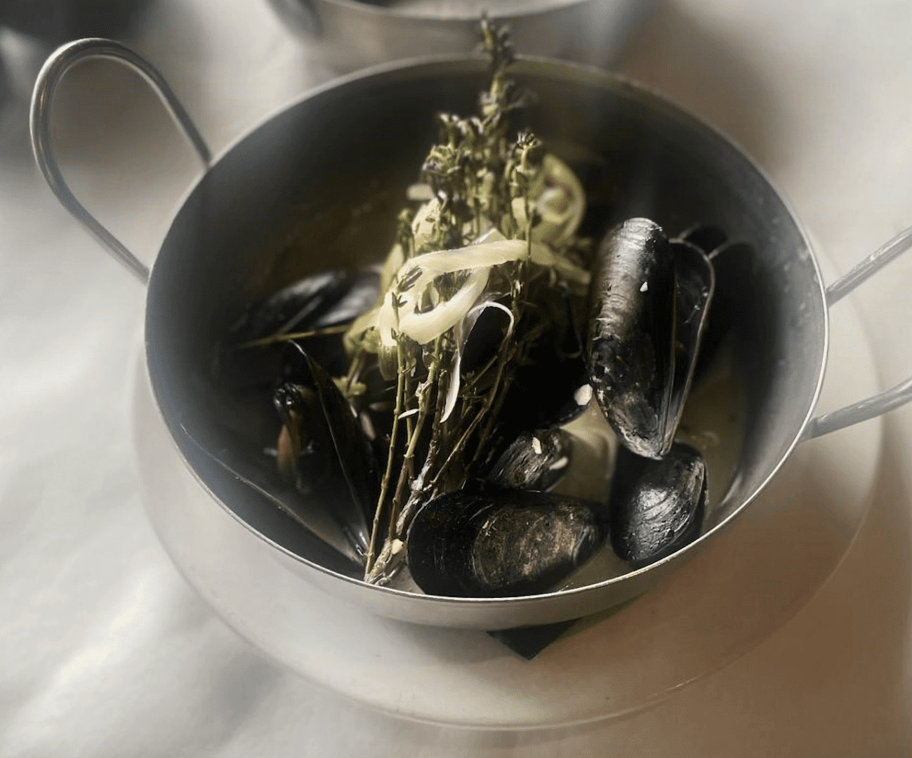 Delicious Mussels recipes in a pot on a white plate.