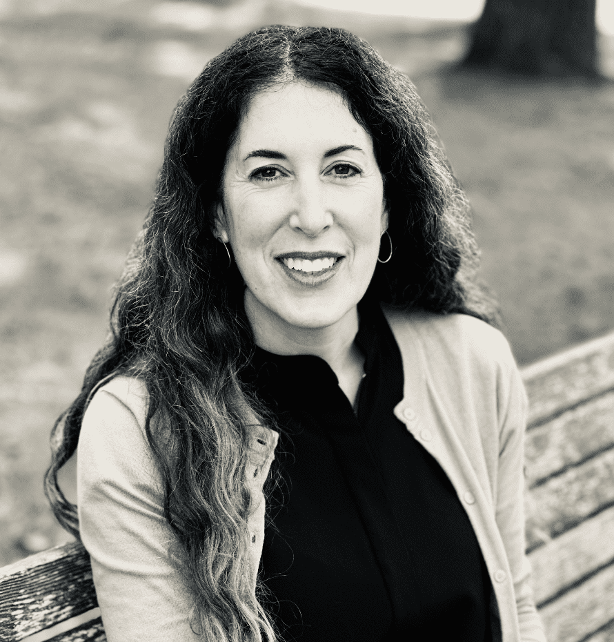 A black and white photo of a woman sitting on a bench, capturing the essence of peacefulness.