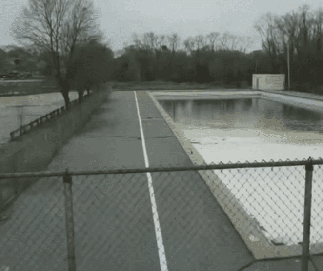 An empty swimming pool with a fence around it in Cranston.