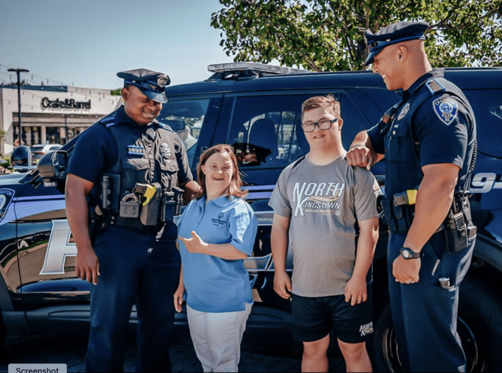 A group of people standing in front of a police car.