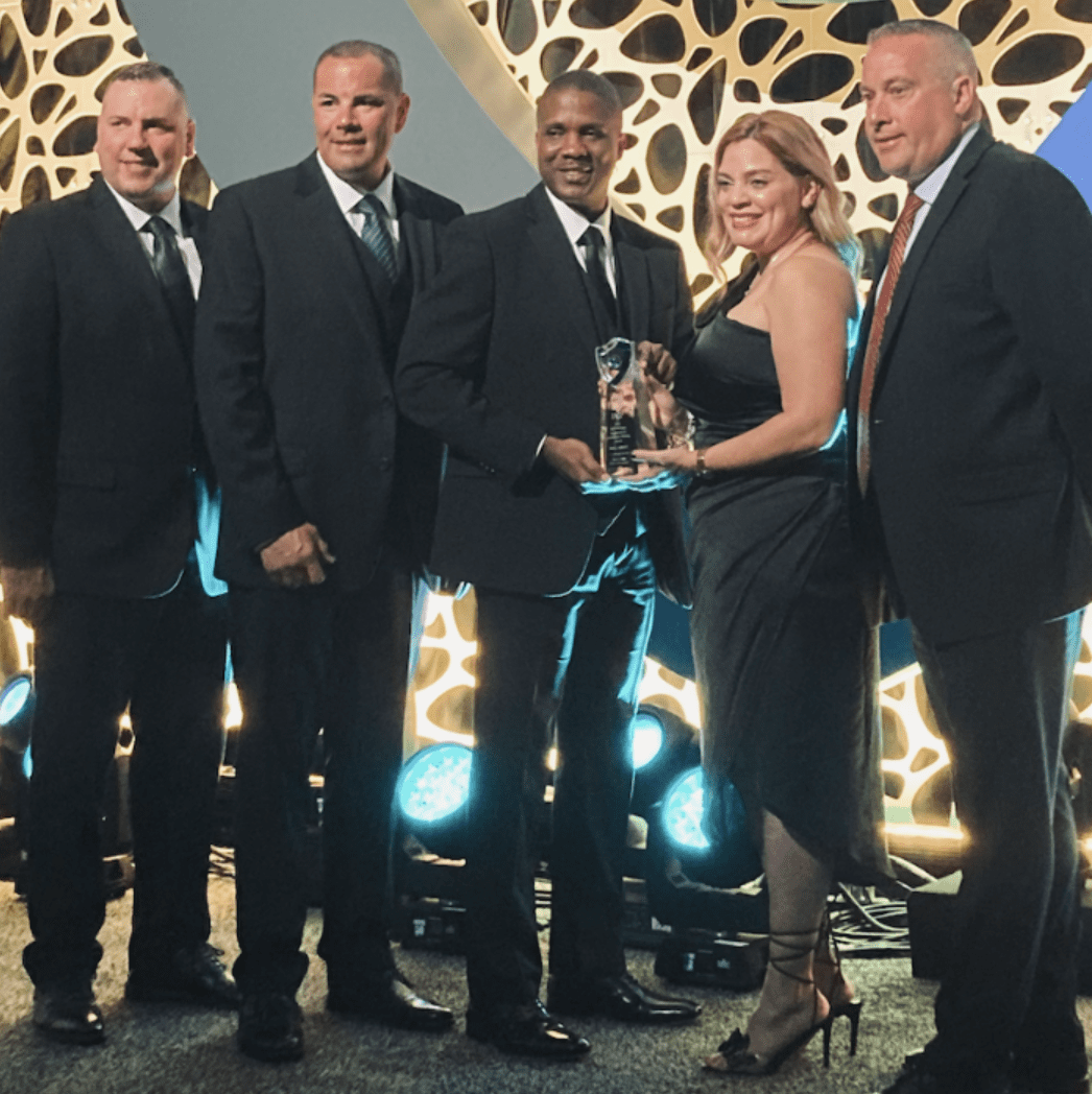 A group of people from Central Falls posing for a photo with an award.