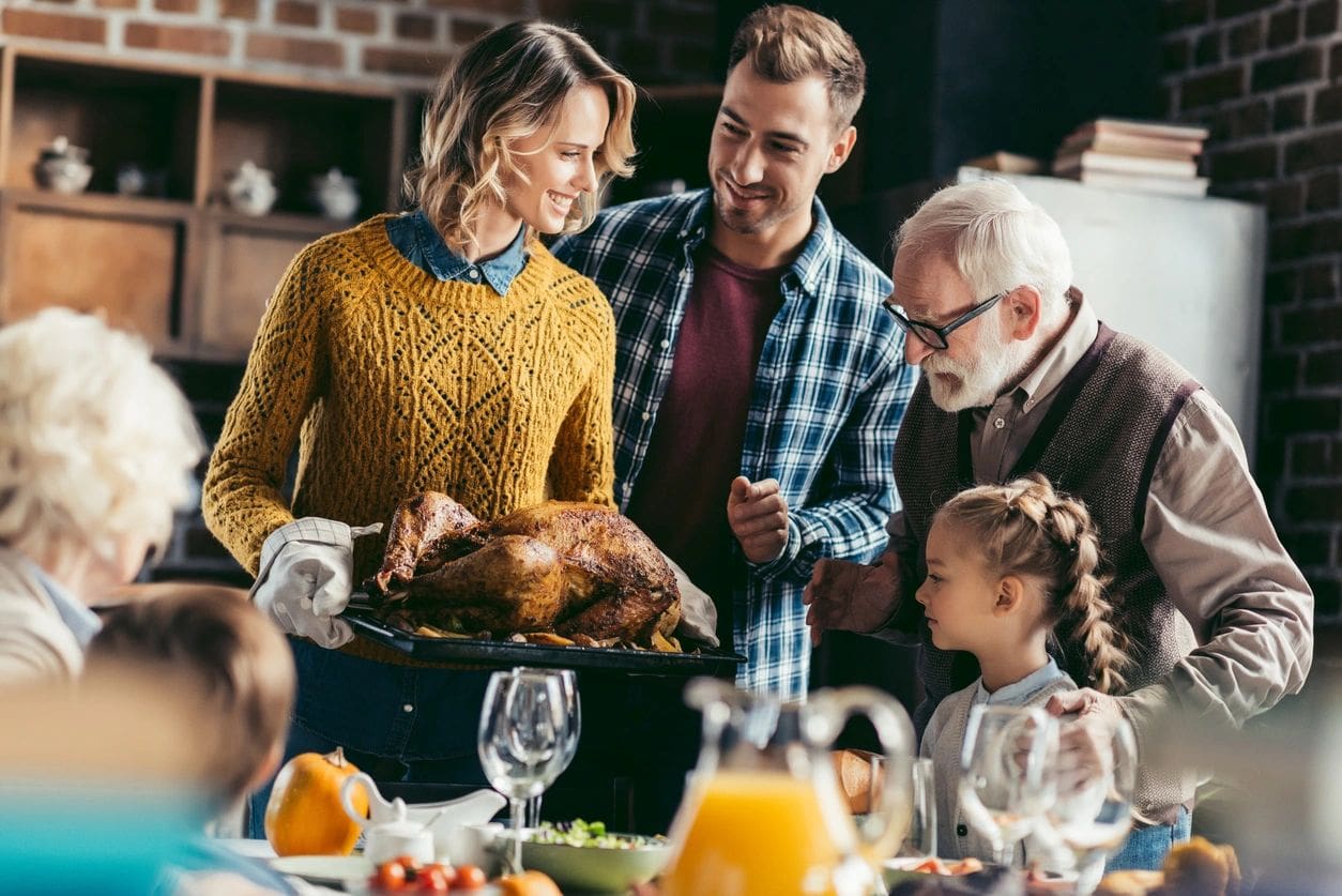 A family is preparing a turkey for thanksgiving dinner.