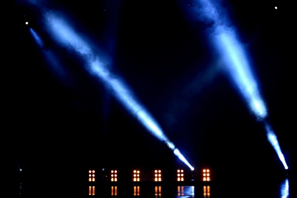 A stage with blue lights and a black background.