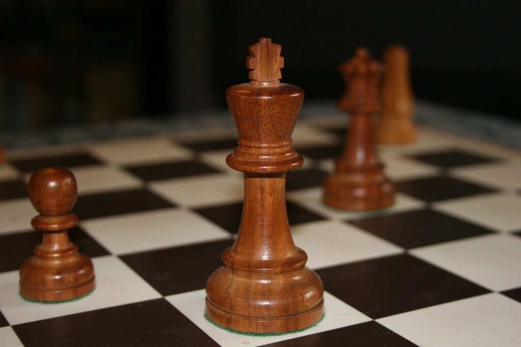 Wooden chess pieces on a chess board.