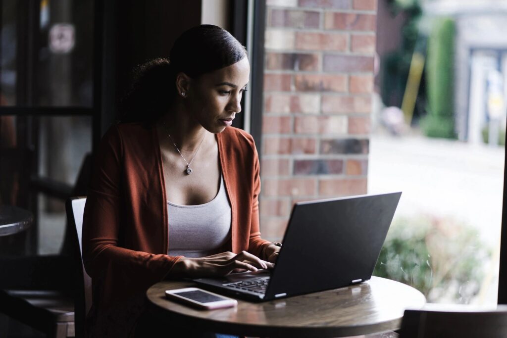 A woman sitting at a table using a laptop.