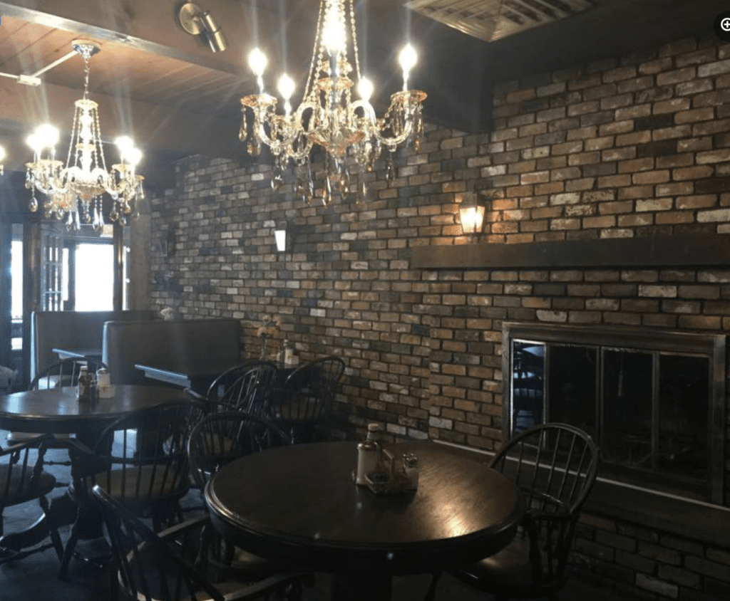 A restaurant featuring a chandelier and a brick wall, offering a charming atmosphere for networking events.