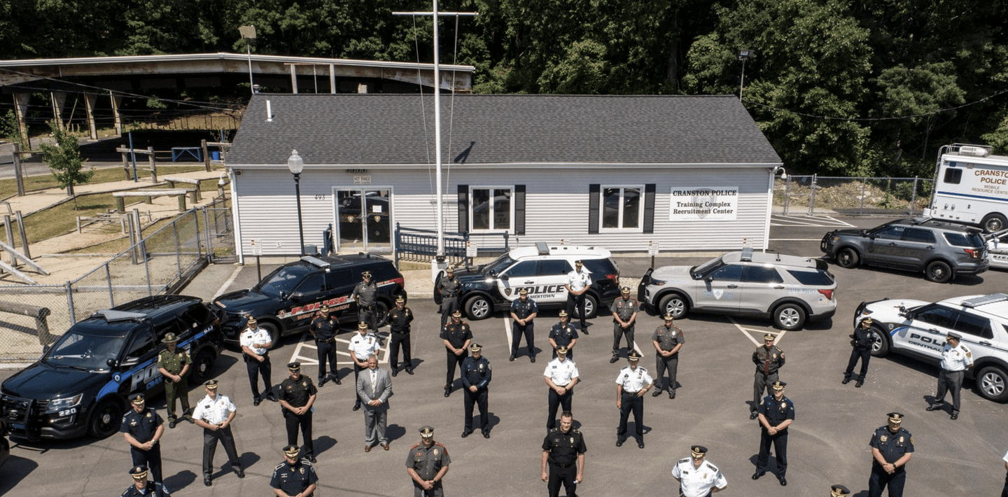 A group of police officers standing in front of a building in Cranston.