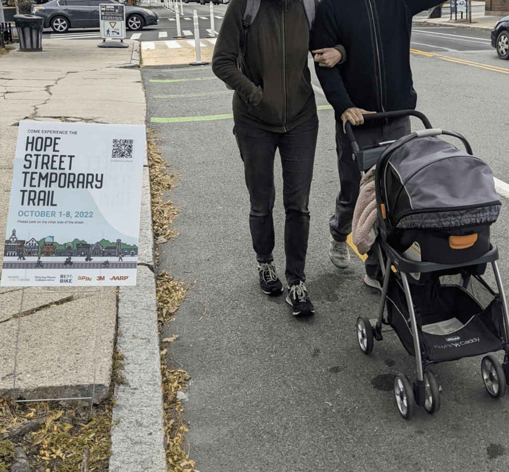 A man and woman stroll down Hope Street, their laughter filling the air as they push a stroller along the sidewalks.