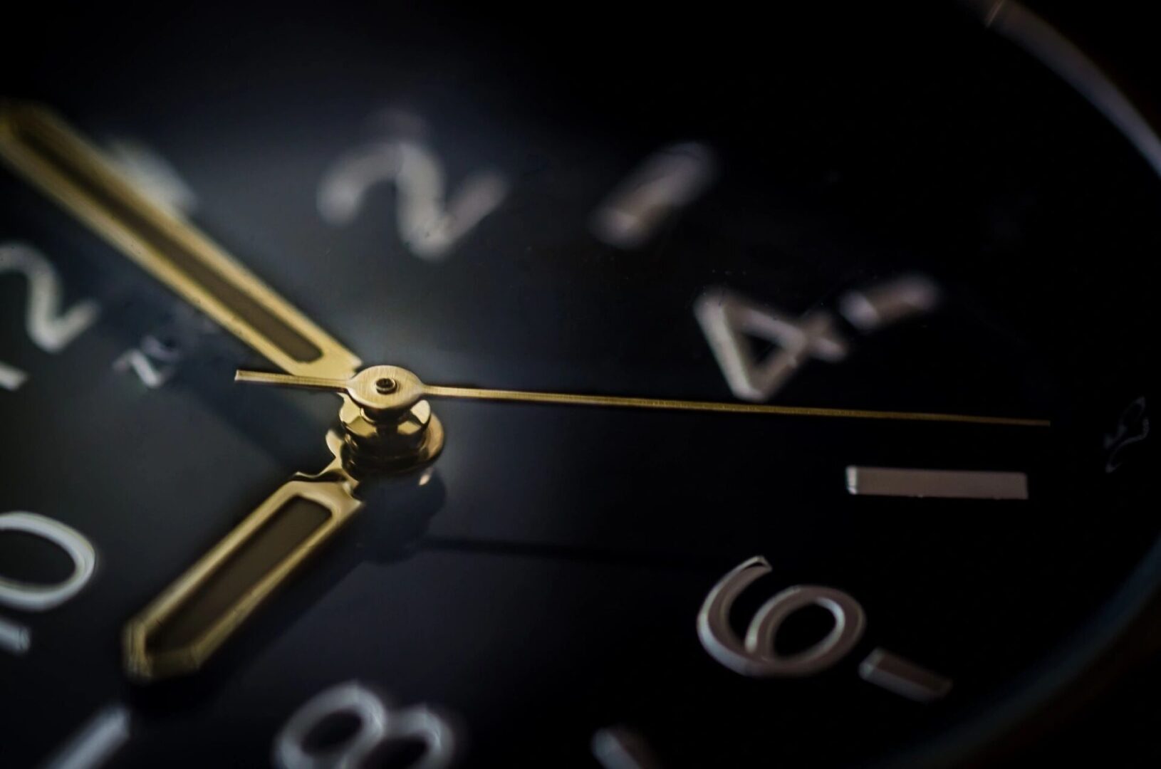 A close up of a clock on a black background.