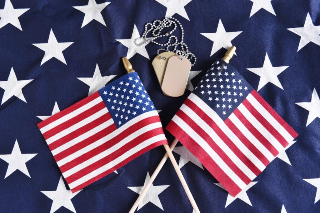 Two american flags and a dog tag on a white background.