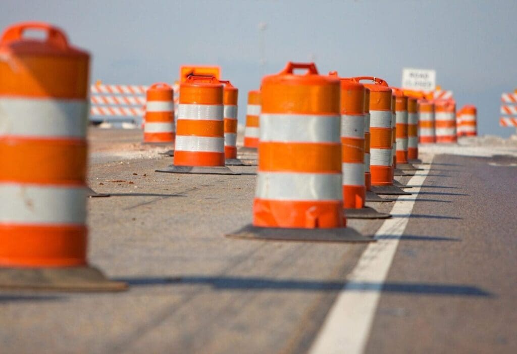 A line of orange and white construction cones on a road.