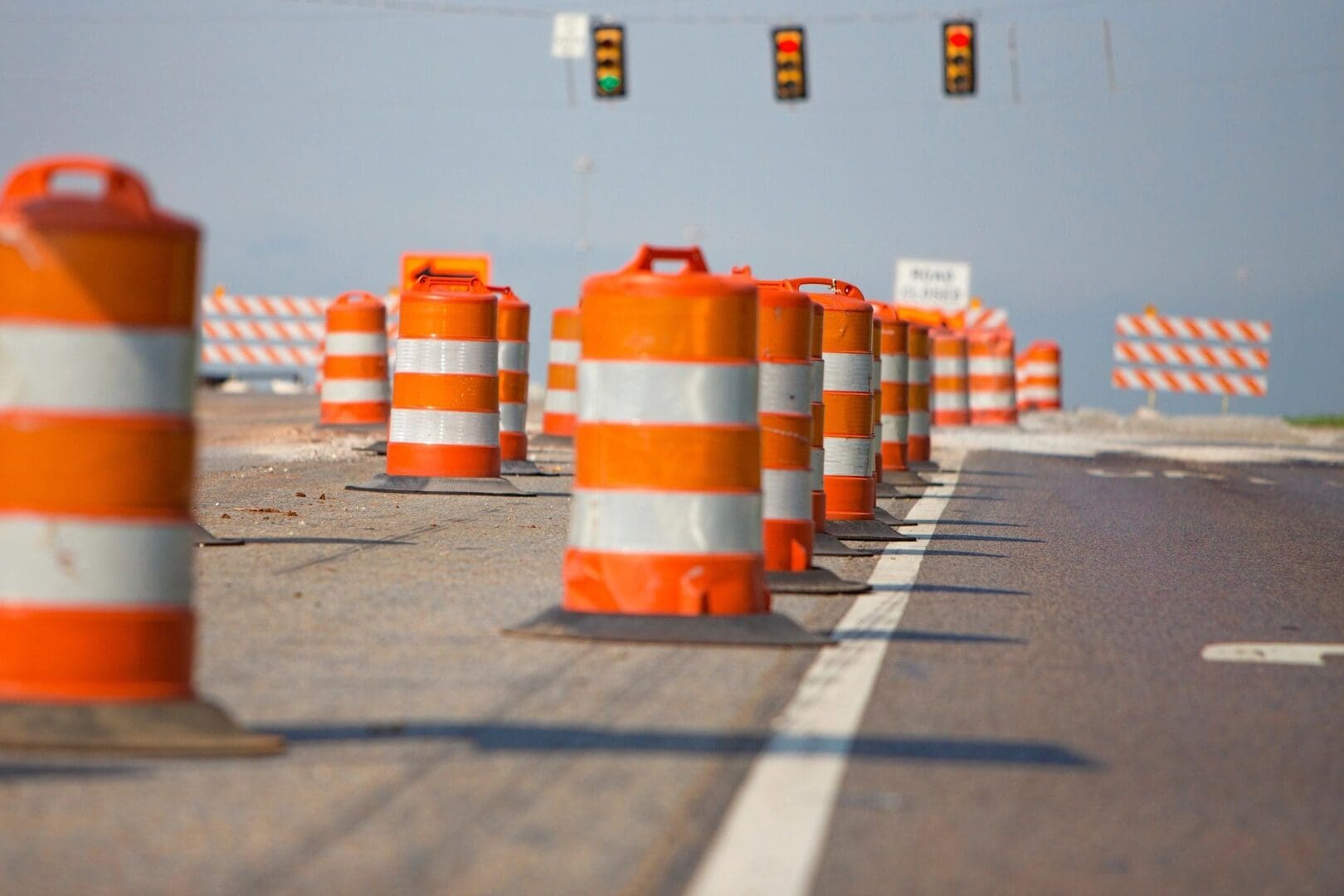A line of orange and white construction cones on a road.