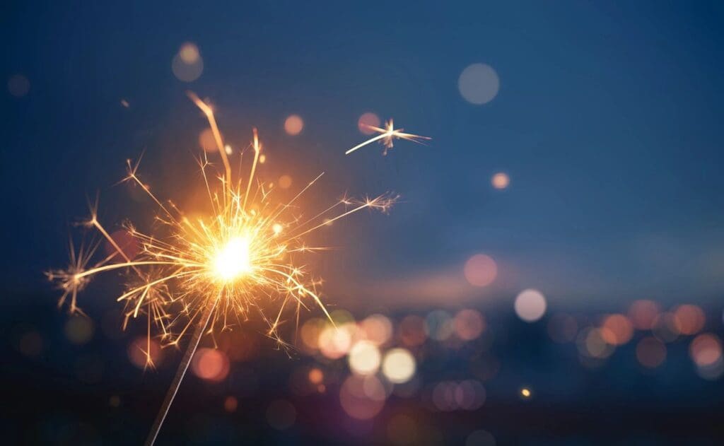 A sparkler with bokeh lights in the background.