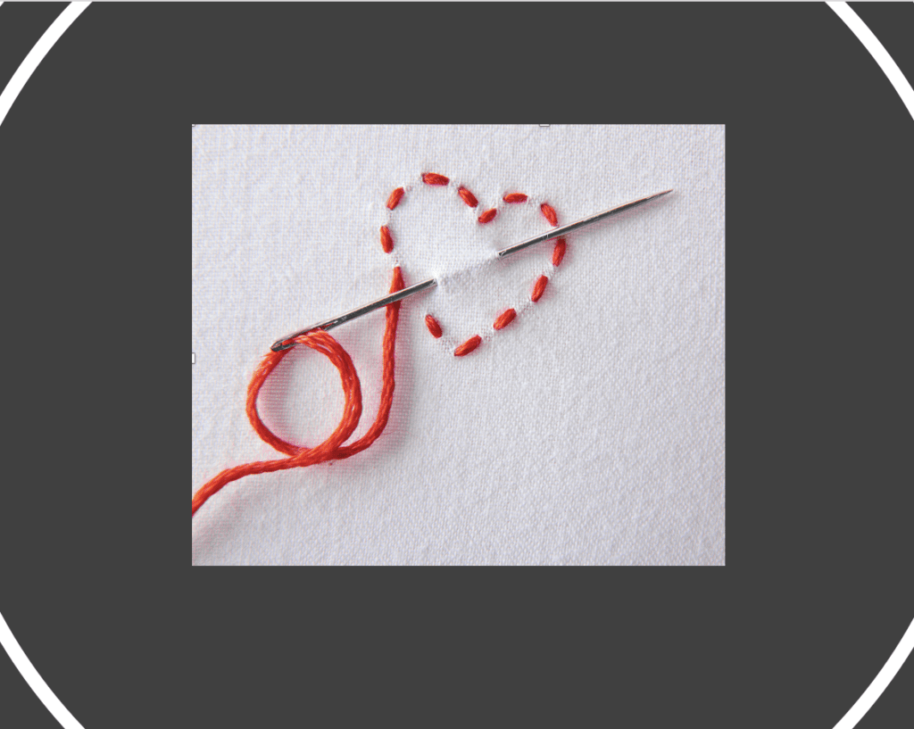 A needle with a red heart on it, symbolizing grief.