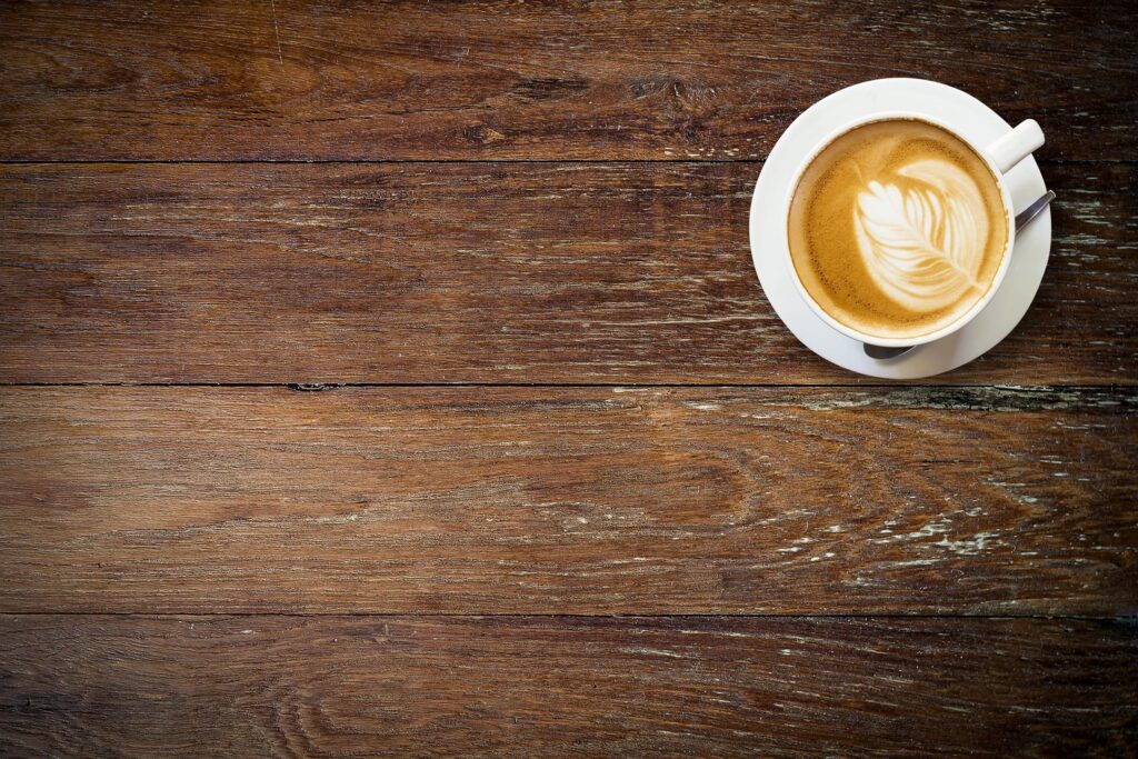 A cup of coffee on a wooden table.