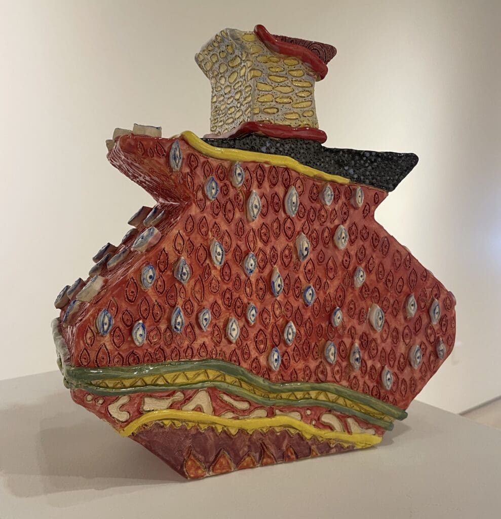 An art museum displays a red and yellow ceramic art vase.