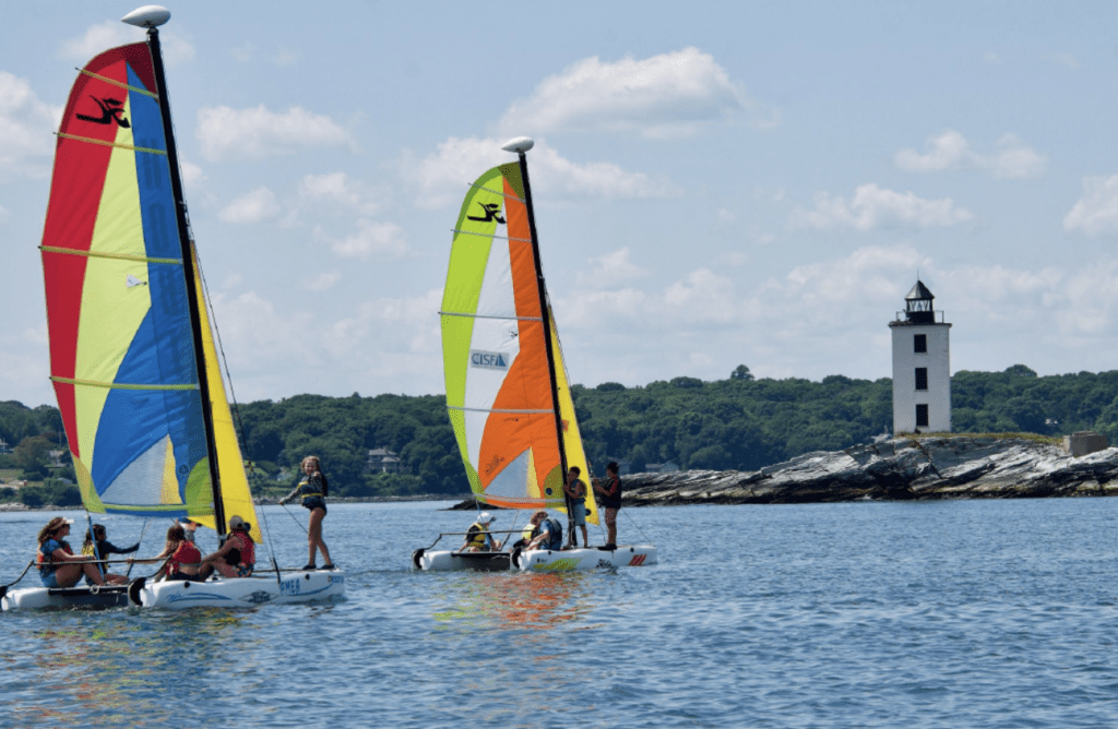 A group of sailing sailboats in the water.
