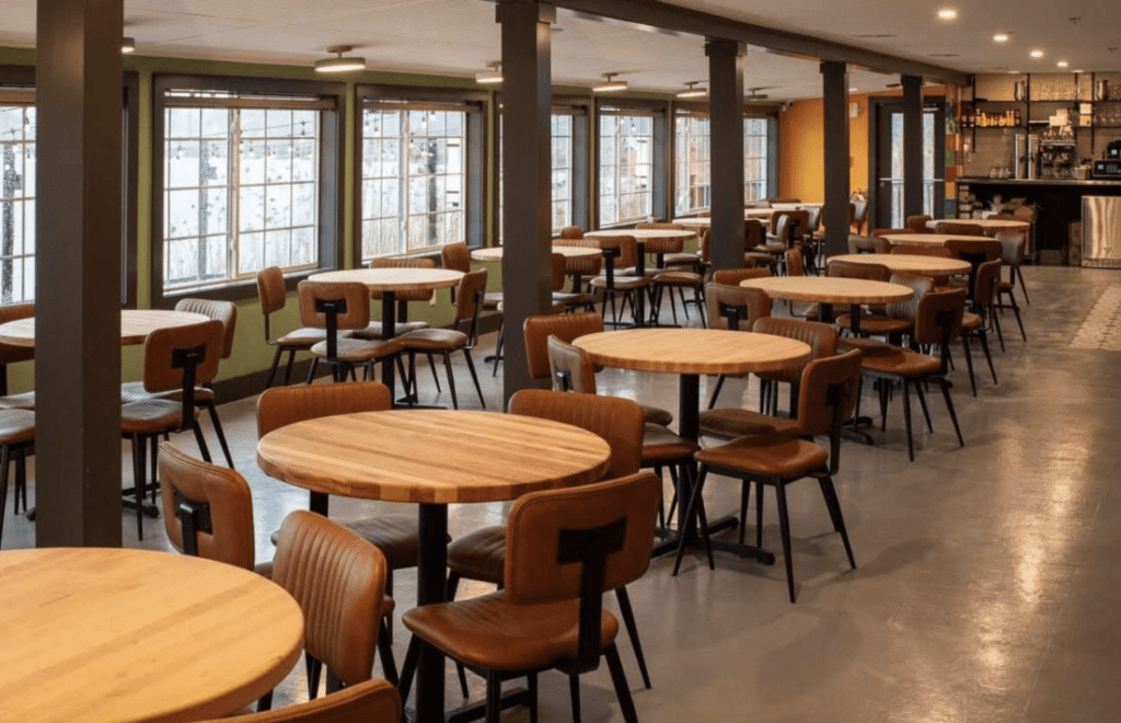 The interior of a restaurant with tables and chairs is designed for networking.