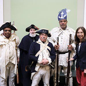 A group of people dressed as the 1st Rhode Island Regiment, a Black Regiment, posing for a photo.