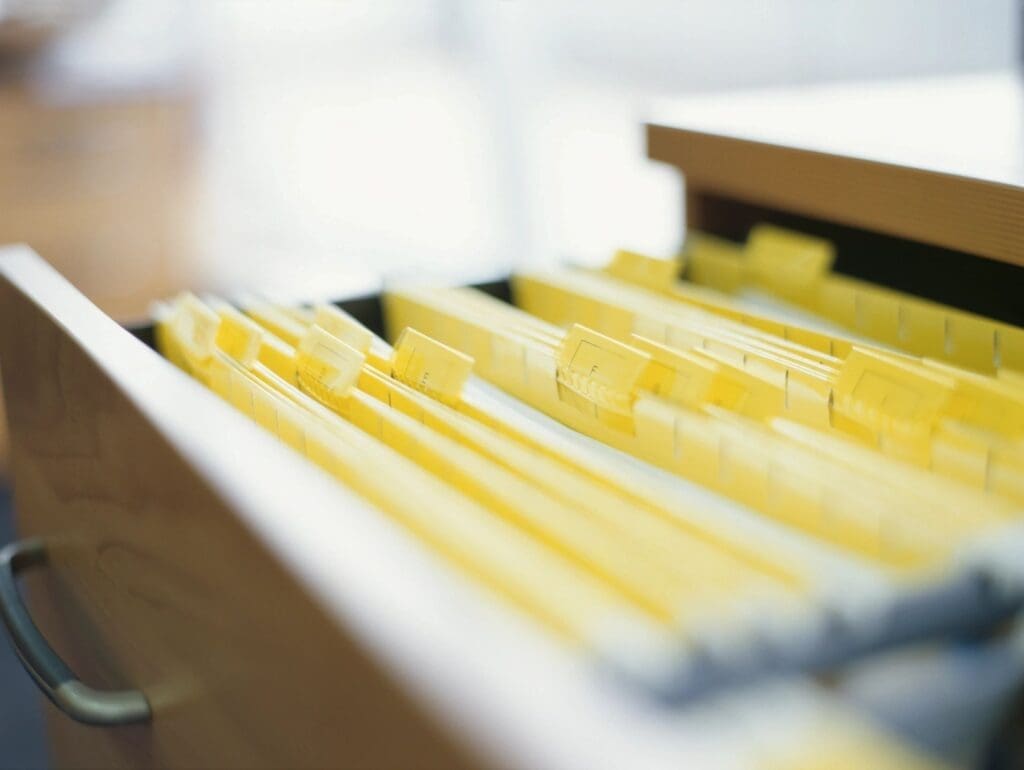 A drawer full of yellow file folders on a desk.