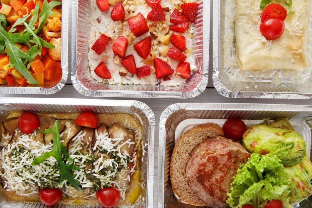 A variety of food in plastic containers on a white background.