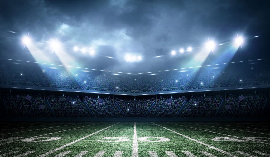 An american football stadium with spotlights on the field.