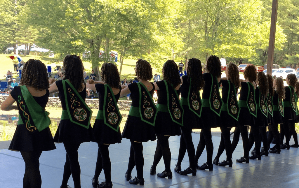 A group of girls performing Irish step dancing on a stage.