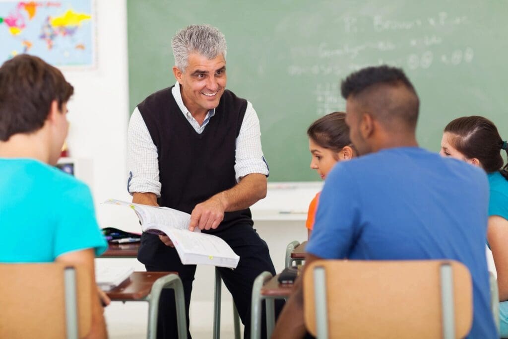 A man is teaching a class of students in a classroom.