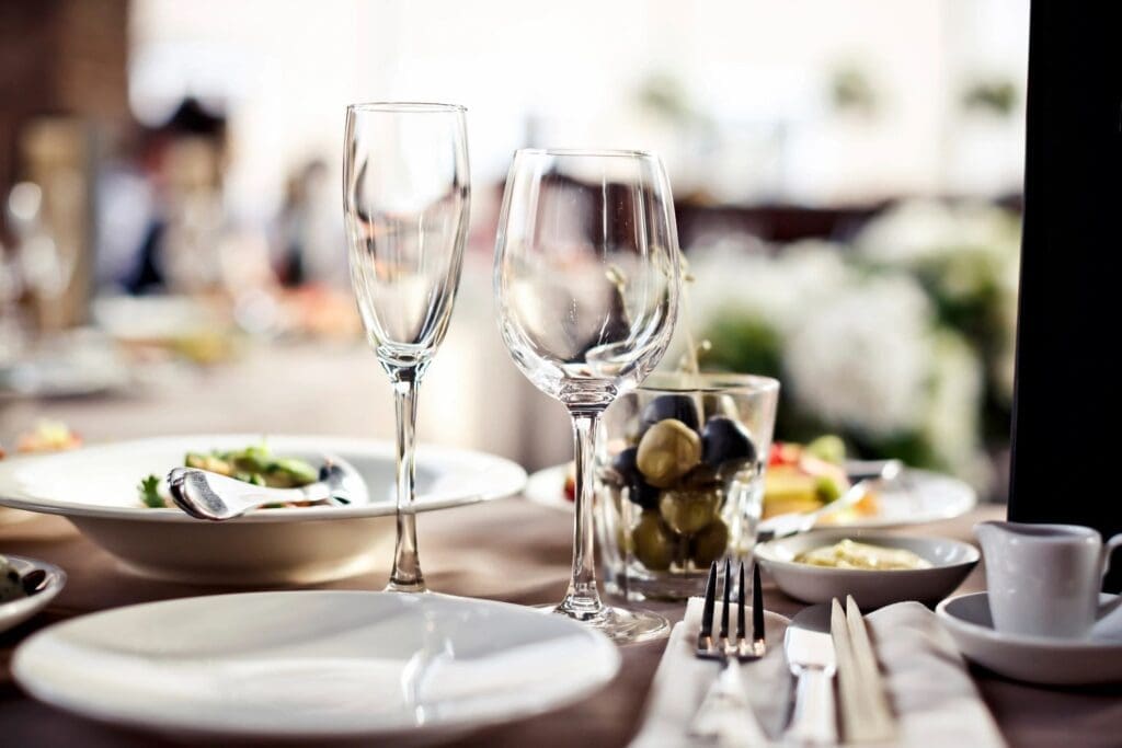 A table setting with wine glasses, plates and silverware.