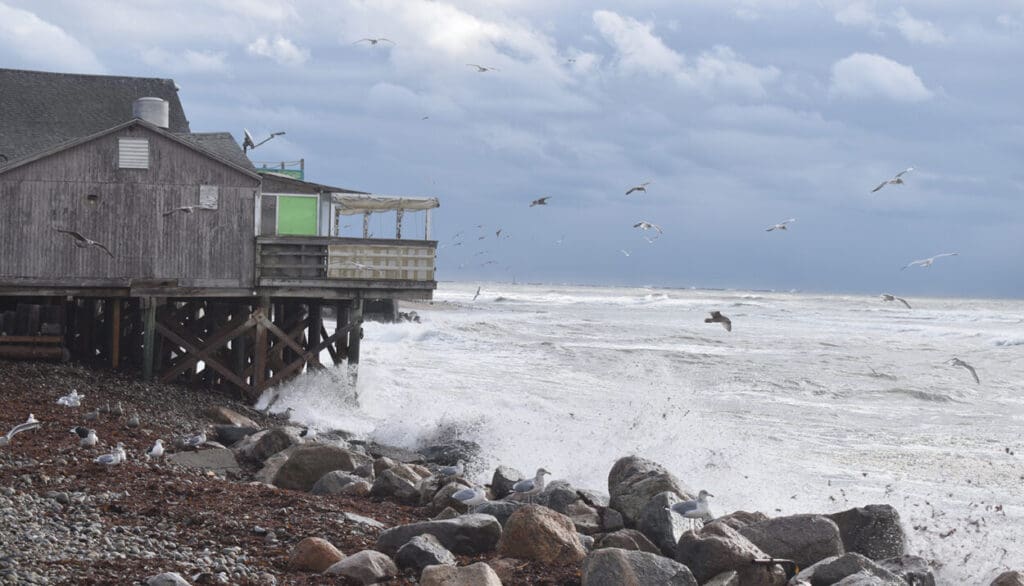 Stormy sea crashing against seaside building.