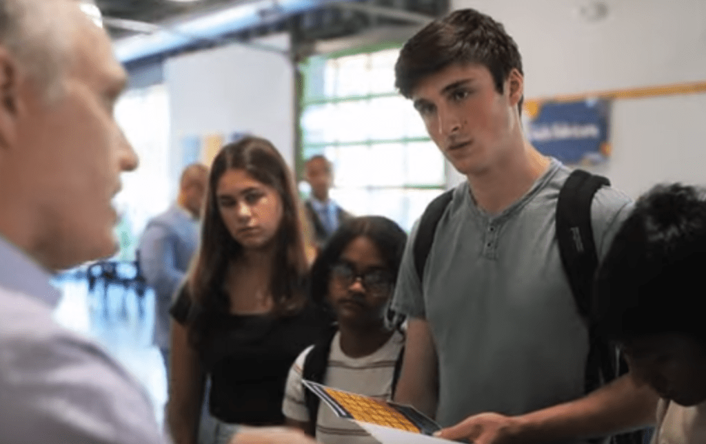 Students show teacher a project.