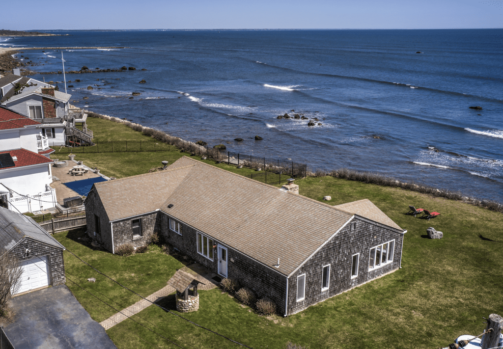 Oceanfront cottage with lawn and pool.