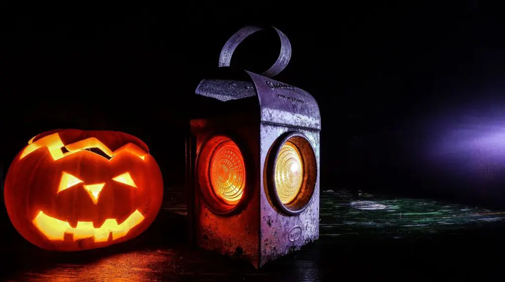 Lit jack-o'-lantern and antique lantern.