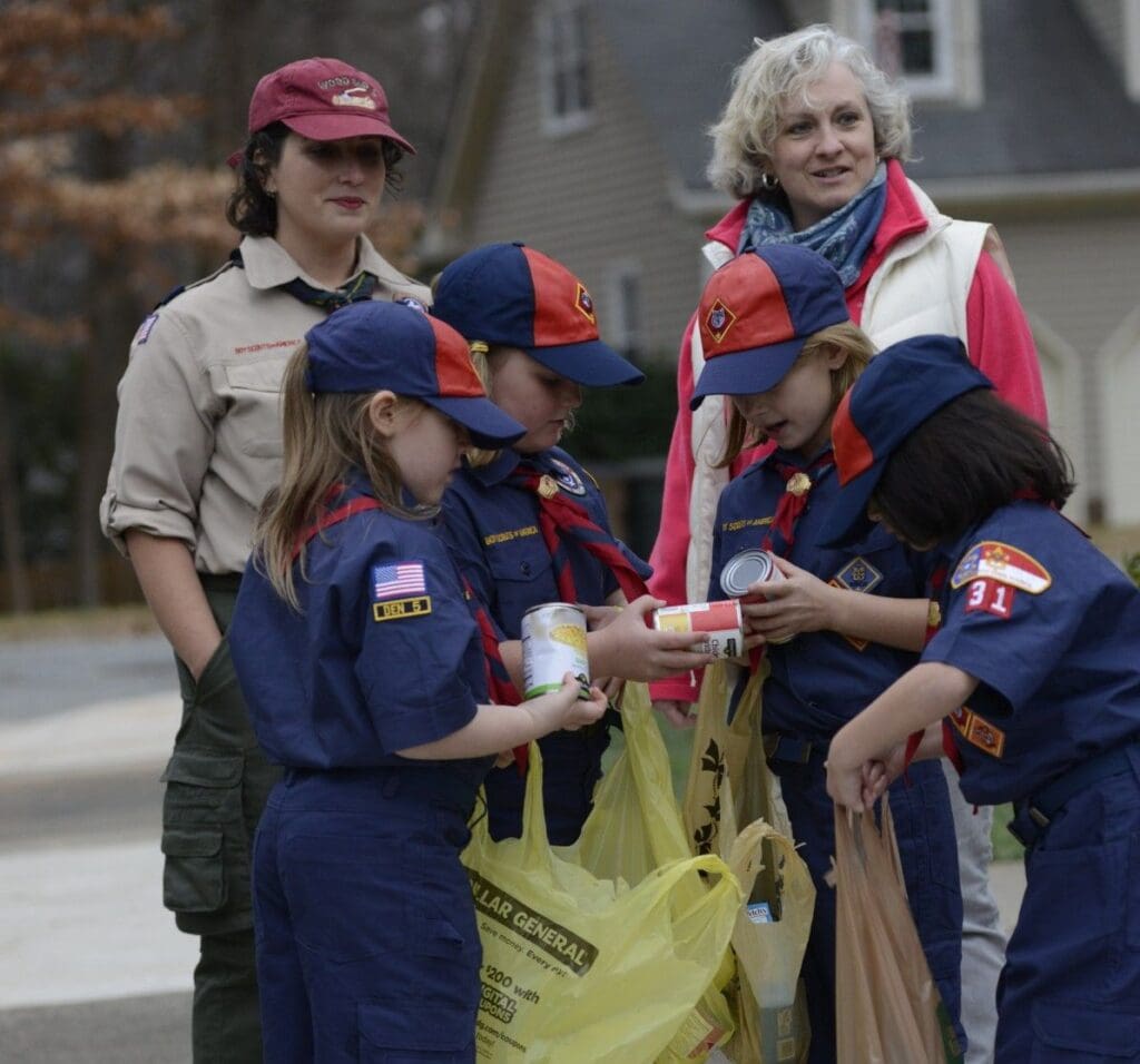Girl Scouts collecting canned goods.